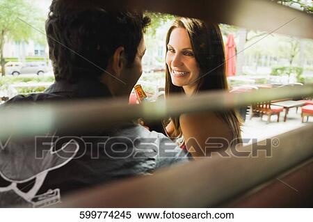 Side profile of a young woman looking at a young man and smiling View Large Photo Image Stock Photography - Side profile of a young woman looking at a young man and smiling. Fotosearch