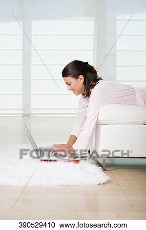 Side profile of a young woman lying on the bed and using a laptop View Large Photo Image Stock Image - Side profile of a young woman lying on the bed and using a laptop. Fotosearch