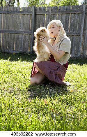 Side profile of a young woman playing with her puppy in a park View Large Photo Image Stock Image - Side profile of a young woman playing with her puppy in a park. Fotosearch