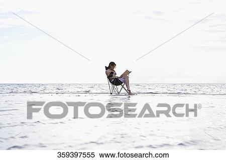 Side profile of a young woman sitting in a folding chair View Large Photo Image Stock Photography - Side profile of a young woman sitting in a folding chair. Fotosearch