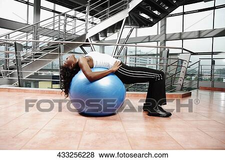Side profile of a young woman exercising on a fitness ball View Large Photo Image Stock Photo - Side profile of a young woman exercising on a fitness ball. Fotosearch