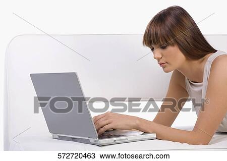 Side profile of a young woman using a laptop View Large Photo Image Stock Image - Side profile of a young woman using a laptop. Fotosearch