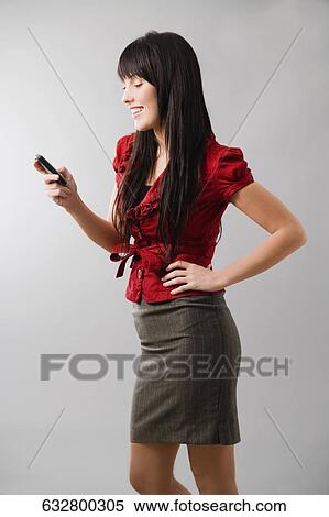 Side profile of a young woman using a mobile phone and smiling View Large Photo Image Stock Photography - Side profile of a young woman using a mobile phone and smiling. Fotosearch