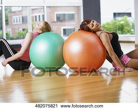 Side profile of two young women exercising with fitness balls View Large Photo Image Stock Image - Side profile of two young women exercising with fitness balls. Fotosearch