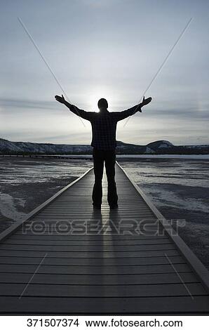 Silhouette of a man standing on a pier with his arms outstretched, Grand Prismatic Spring, Yellowstone National park, Wyoming, USA View Large Photo Image Picture - Silhouette of a man standing on a pier with his arms outstretched, Grand Prismatic Spring, Yellowstone National park, Wyoming, USA. Fotosearch