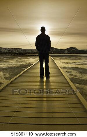 Silhouette of a man standing on a pier, Grand Prismatic Spring, Yellowstone National park, Wyoming, USA View Large Photo Image Stock Image - Silhouette of a man standing on a pier, Grand Prismatic Spring, Yellowstone National park, Wyoming, USA. Fotosearch
