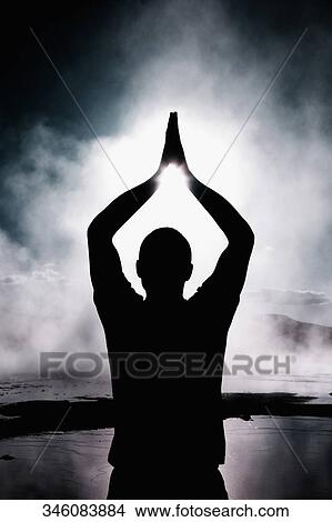 Picture - Silhouette of a person practicing yoga. Fotosearch