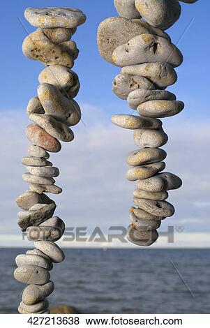 Stacks of pebbles with sea in the background View Large Photo Image Stock Photo - Stacks of pebbles with sea in the background. Fotosearch