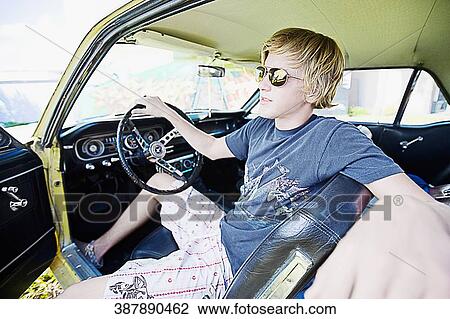 Teenage boy sitting in a car View Large Photo Image Stock Image - Teenage boy sitting in a car. Fotosearch