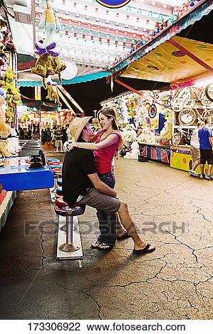 Teenage couple embracing each other in an amusement park View Large Photo Image Stock Image - Teenage couple embracing each other in an amusement park. Fotosearch