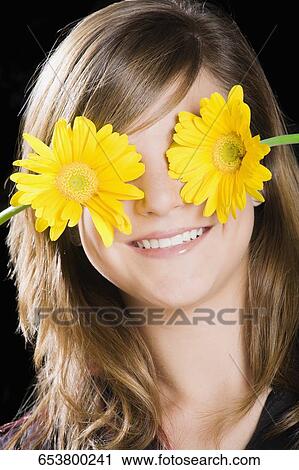 Teenage girl covering her eyes with flowers View Large Photo Image Stock Image - Teenage girl covering her eyes with flowers. Fotosearch