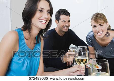 Three friends drinking wine and smiling together View Large Photo Image Stock Photography - Three friends drinking wine and smiling together. Fotosearch