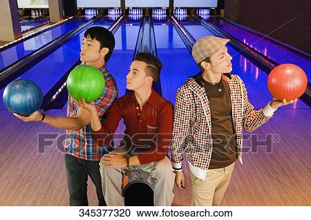 Three young men looking at bowling balls View Large Photo Image Stock Image - Three young men looking at bowling balls. Fotosearch