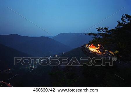 Tourists sitting around fire View Large Photo Image Stock Image - Tourists sitting around fire. Fotosearch