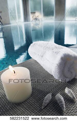 Towel with a burning candle and sea shells at the poolside View Large Photo Image Stock Image - Towel with a burning candle and sea shells at the poolside. Fotosearch