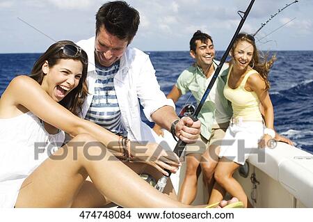 Picture - Two couples fishing in the sea. Fotosearch