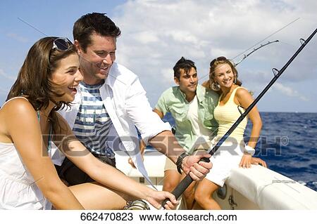 Stock Image - Two couples fishing in the sea. Fotosearch
