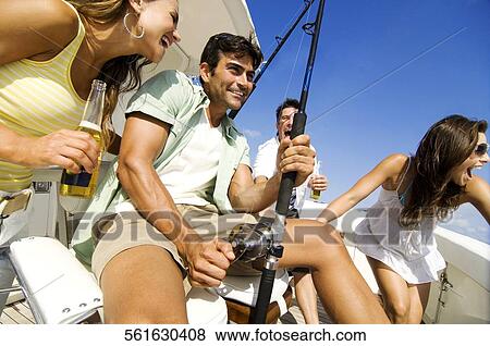 Two couples sitting in a boat and fishing View Large Photo Image Stock Photo - Two couples sitting in a boat and fishing. Fotosearch