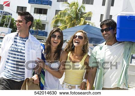 Two couples walking together and smiling View Large Photo Image Stock Image - Two couples walking together and smiling. Fotosearch