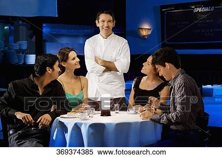 Two couples with a male chef in a restaurant View Large Photo Image Stock Photography - Two couples with a male chef in a restaurant. Fotosearch