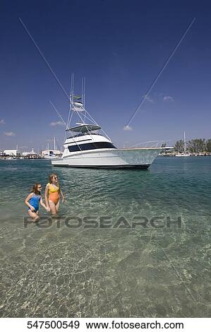Two girls standing in the sea View Large Photo Image Stock Photo - Two girls standing in the sea. Fotosearch