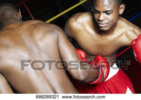 Two male boxers fighting in a boxing ring View Large Photo Image Stock Image - Two male boxers fighting in a boxing ring. Fotosearch