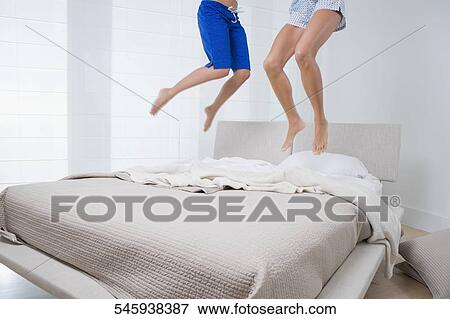 Two people jumping on the bed View Large Photo Image Stock Photo - Two people jumping on the bed. Fotosearch