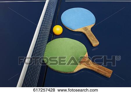 Two table tennis rackets with a ball on a table tennis table View Large Photo Image Stock Photo - Two table tennis rackets with a ball on a table tennis table. Fotosearch