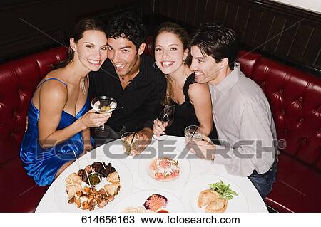 Two young couples sitting at a table in a restaurant and smiling View Large Photo Image Stock Image - Two young couples sitting at a table in a restaurant and smiling. Fotosearch