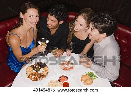 Two young couples sitting at a table in a restaurant and smiling View Large Photo Image Stock Photography - Two young couples sitting at a table in a restaurant and smiling. Fotosearch