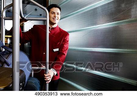 Waiter carrying luggage in a luggage rack View Large Photo Image Stock Image - Waiter carrying luggage in a luggage rack. Fotosearch