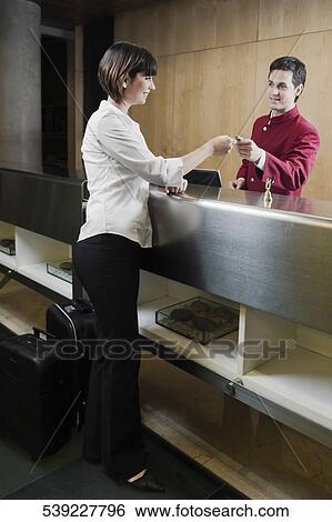 Waiter giving cardkey to a customer View Large Photo Image Stock Photograph - Waiter giving cardkey to a customer. Fotosearch