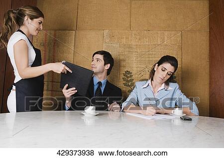 Waitress giving a menu to a businessman View Large Photo Image Stock Photo - Waitress giving a menu to a businessman. Fotosearch