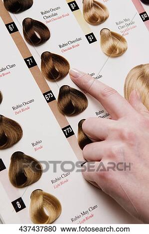 Stock Image - Woman choosing a hair color from a color swatch. Fotosearch