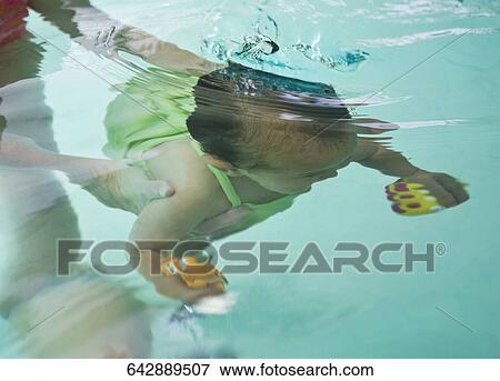 Woman holding her daughter underwater View Large Photo Image Stock Photo - Woman holding her daughter underwater. Fotosearch