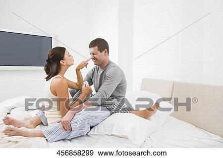 Young couple applying facial mask on a young man's face View Large Photo Image Stock Photo - Young couple applying facial mask on a young man's face. Fotosearch