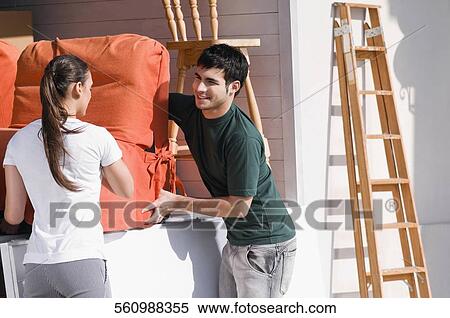 Young couple carrying an armchair View Large Photo Image Stock Photography - Young couple carrying an armchair. Fotosearch
