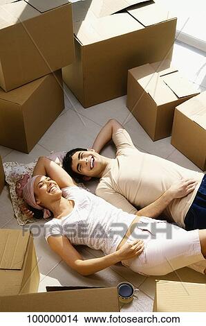 Young couple lying on the floor and smiling View Large Photo Image Picture - Young couple lying on the floor and smiling. Fotosearch