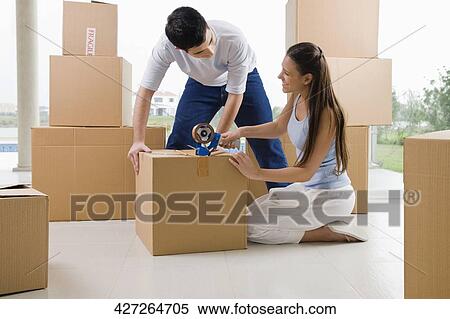 Young couple packing a cardboard box View Large Photo Image Stock Photography - Young couple packing a cardboard box. Fotosearch