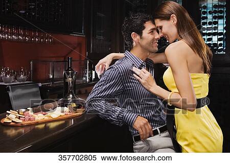 Young couple romancing at a bar counter and smiling View Large Photo Image Stock Photography - Young couple romancing at a bar counter and smiling. Fotosearch