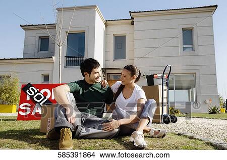 Young couple sitting in front of a sold information board View Large Photo Image Picture - Young couple sitting in front of a sold information board. Fotosearch