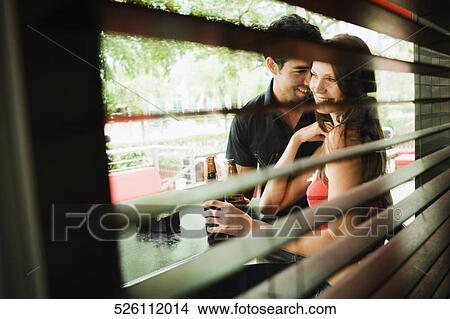 Young couple smiling together at a sidewalk cafe View Large Photo Image Picture - Young couple smiling together at a sidewalk cafe. Fotosearch