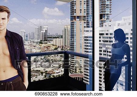 Stock Photo - Young couple standing in a balcony. Fotosearch