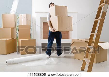 Stock Photograph - Young man carrying cardboard boxes. Fotosearch