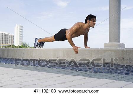 Young man doing push ups on the ledge View Large Photo Image Stock Image - Young man doing push ups on the ledge. Fotosearch