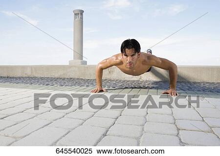 Young man doing push ups View Large Photo Image Stock Photography - Young man doing push ups. Fotosearch