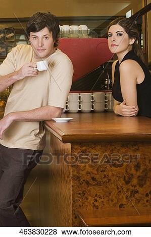 Young man drinking coffee in a cafe View Large Photo Image Stock Photo - Young man drinking coffee in a cafe. Fotosearch