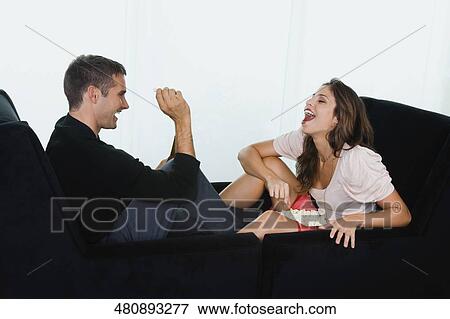 Young man feeding popcorn to a young woman View Large Photo Image Stock Photo - Young man feeding popcorn to a young woman. Fotosearch