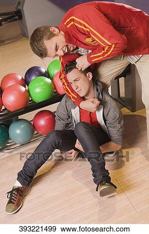 Stock Photo - Young man gripping another young man's neck. Fotosearch