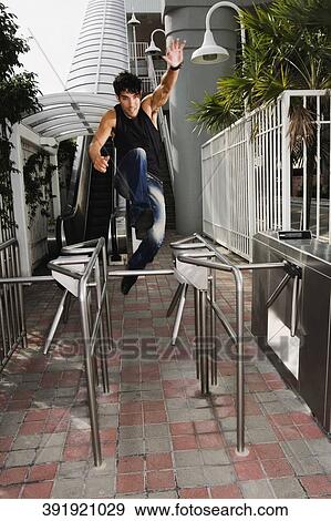 Young man jumping a barrier View Large Photo Image Stock Photo - Young man jumping a barrier. Fotosearch